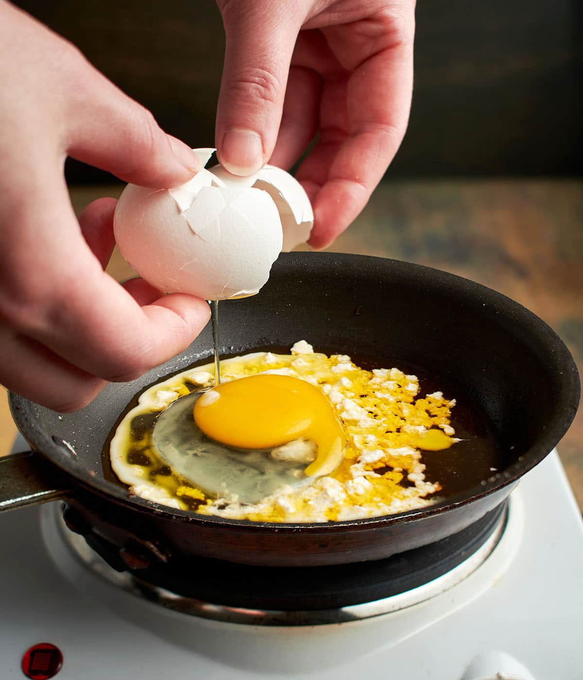 crack eggs in oil with feta